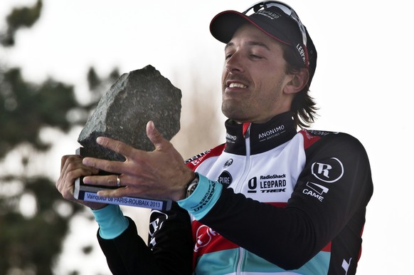 Switzerland&#039;s Fabian Cancellara of the Radioshack Leopard team, holds the cobblestone trophy aloft after winning the 111th Paris-Roubaix classic cycling race in Roubaix, Sunday, April 7, 2013. Fa ...