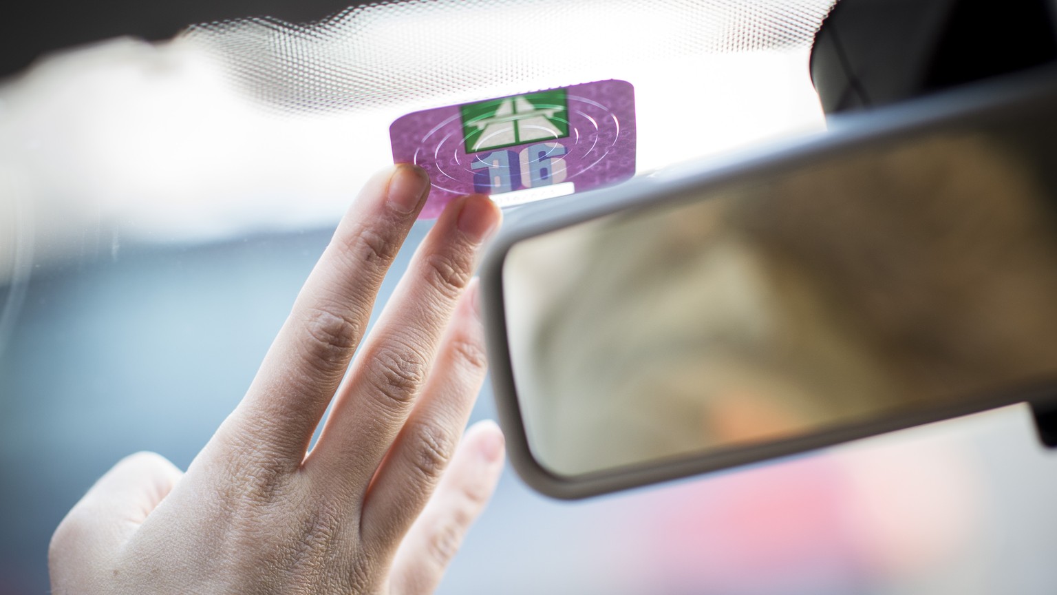 ARCHIV --- ZUM PILOTPROJEKT MOBILITY-PRICING STELLEN WIR IHNEN FOLGENDES BILD ZUR VERFUEGUNG --- Eine Frau klebt die Autobahnvignette fuer das Jahr 2016 an die Frontscheibe ihres Autos, am Dienstag, 2 ...
