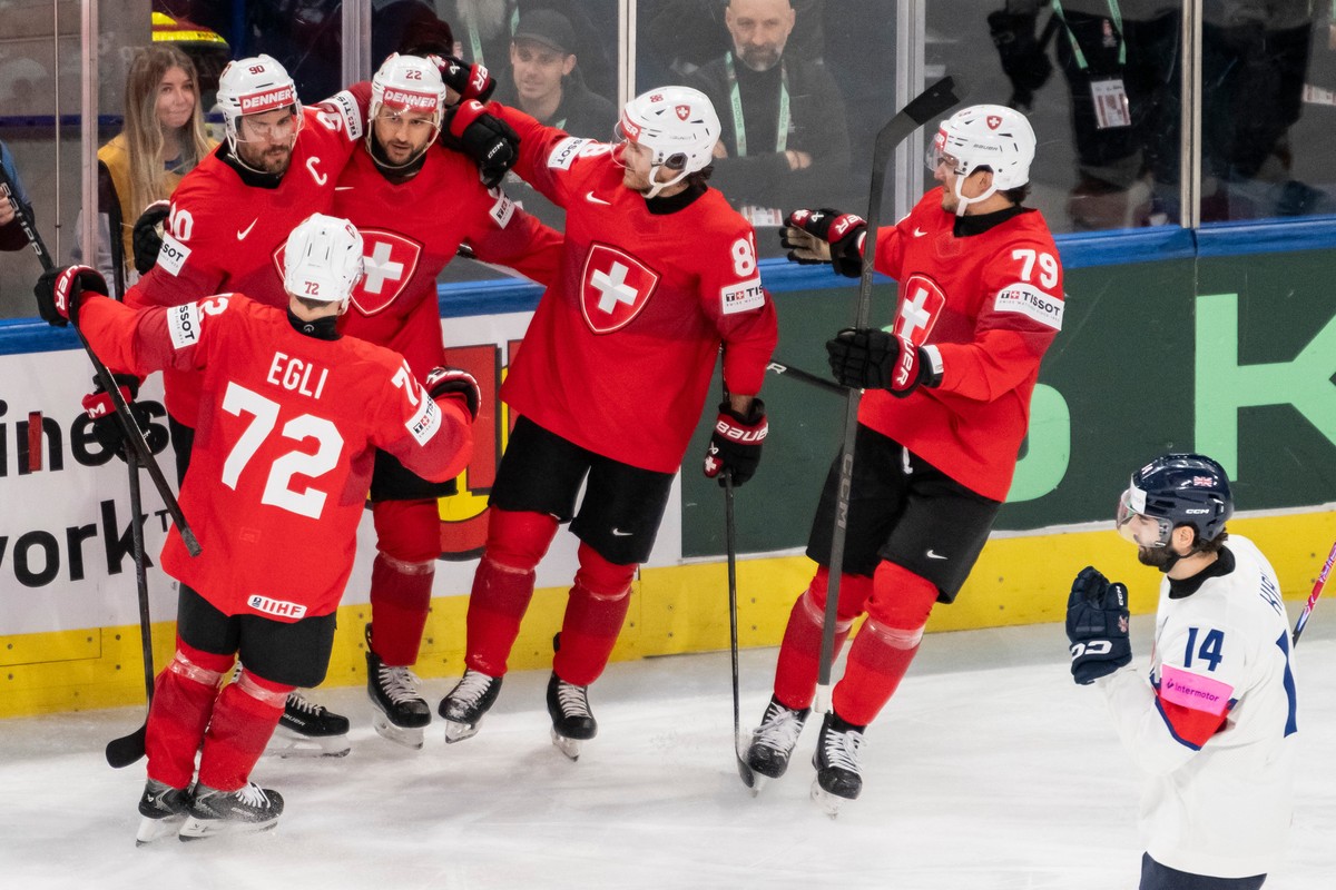 Switzerland's Nino Niederreiter, third left, celebrates with teammates after scoring during the Group A preliminary round game between Switzerland and Great Britain at the men's ice hockey w ...