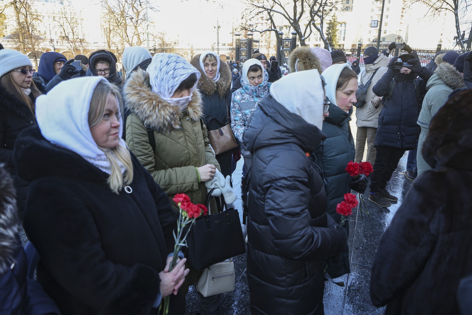 epa11073482 Wives of Russian soldiers who served in the special military operation in Ukraine lay flowers at the Tomb of the Unknown Soldier at the Kremlin Wall in Moscow, Russia, January 13, 2024. Severa...