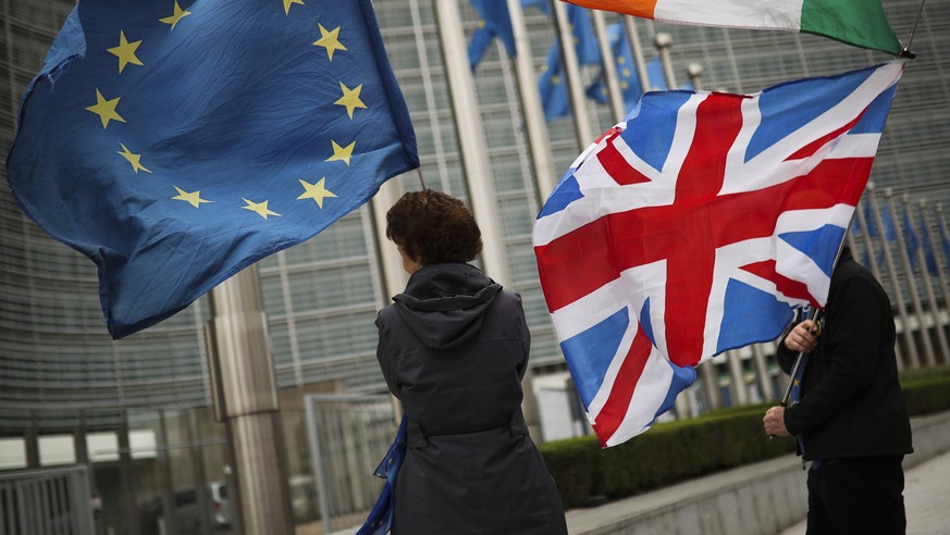 Two anti Brexit people hold EU, Ireland and Union Flags as they wait for the departure of UK Brexit secretary Stephen Barclay during his meeting with European Union chief Brexit negotiator Michel Barn ...