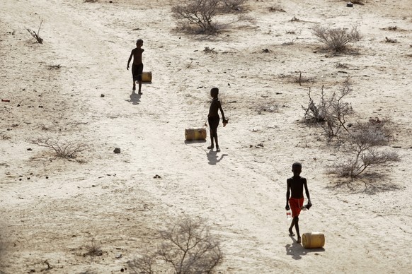 FILE - Young boys pull containers of water as they return to their huts from a well in the village of Ntabasi amid a drought in Samburu East, Kenya, Oct, 14, 2022. Tropical Cyclone Freddy, which has a ...