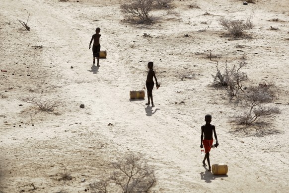 FILE - Young boys pull containers of water as they return to their huts from a well in the village of Ntabasi amid a drought in Samburu East, Kenya October 14, 2022. Tropical Cyclone Freddy, which caused a…