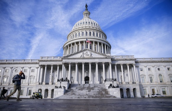 epa07206163 A man walks past the East Front of the US Capitol as workers prepare the area before the late afternoon arrival of the body of former US President George H.W. Bush, in Washington, DC, USA, ...