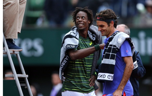 epa04777915 Gael Monfils of France (L) and Roger Federer of Switzerland react after their fourth round match was interrupted and postponed for the next day at the French Open tennis tournament at Rola ...
