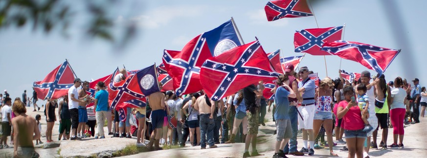 epa04869373 Pro-Confederate flag supporters wave flags as they surround counter-protesters during a Confederate flag rally at Stone Mountain Park in Stone Mountain, Georgia, USA, 01 August 2015. Sever ...