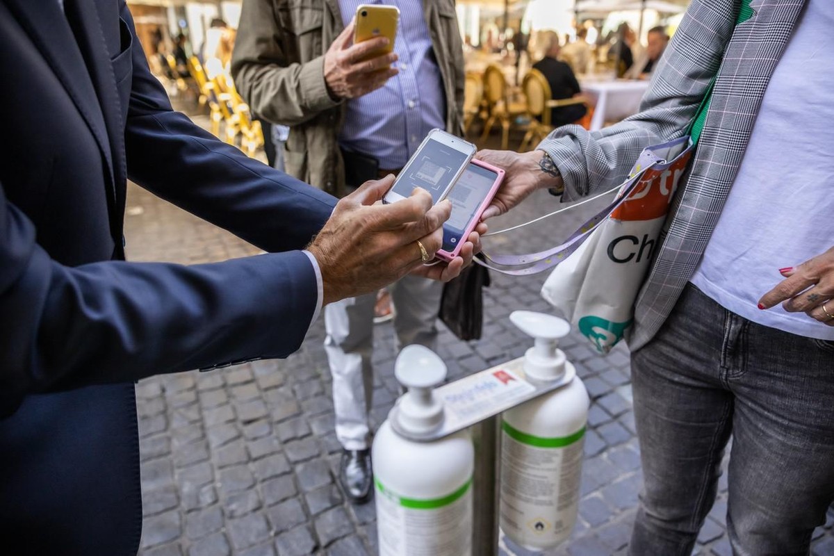 Des clients presentent leur certificat COVID a l?entree d?un restaurant du centre-ville de Geneve, ce lundi, 13 septembre 2021. Des ce lundi 13 septembre, il faut montrer le code QR sur l'app ou  ...