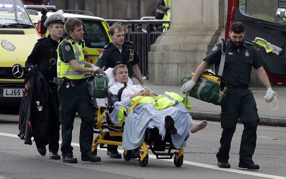 Emergency services transport an injured person to an ambulance, close to the Houses of Parliament in London, Wednesday, March 22, 2017. London police say they are treating a gun and knife incident at Britain's Parliament &quot;as a terrorist incident until we know otherwise.&quot; The Metropolitan Police says in a statement that the incident is ongoing. Officials say a man with a knife attacked a police officer at Parliament and was shot by officers. Nearby, witnesses say a vehicle struck several people on the Westminster Bridge. (AP Photo/Matt Dunham)