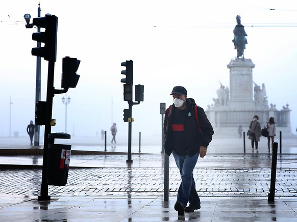 Ein Mann mit Mund-Nasen-Schutz geht durch Lissabon. Foto: Pedro Fiuza/ZUMA Wire/dpa