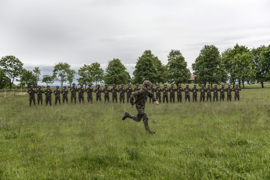 JAHRESRUECKBLICK 2013 - MAI - Rekruten der Infanterie stehen auf der gruenen Wiese in Reih und Glied, waehrend ein weiterer Rekrut vorbeisprintet, aufgenommen am 17. Mai in der Infanterie RS 5 (Rekrut ...