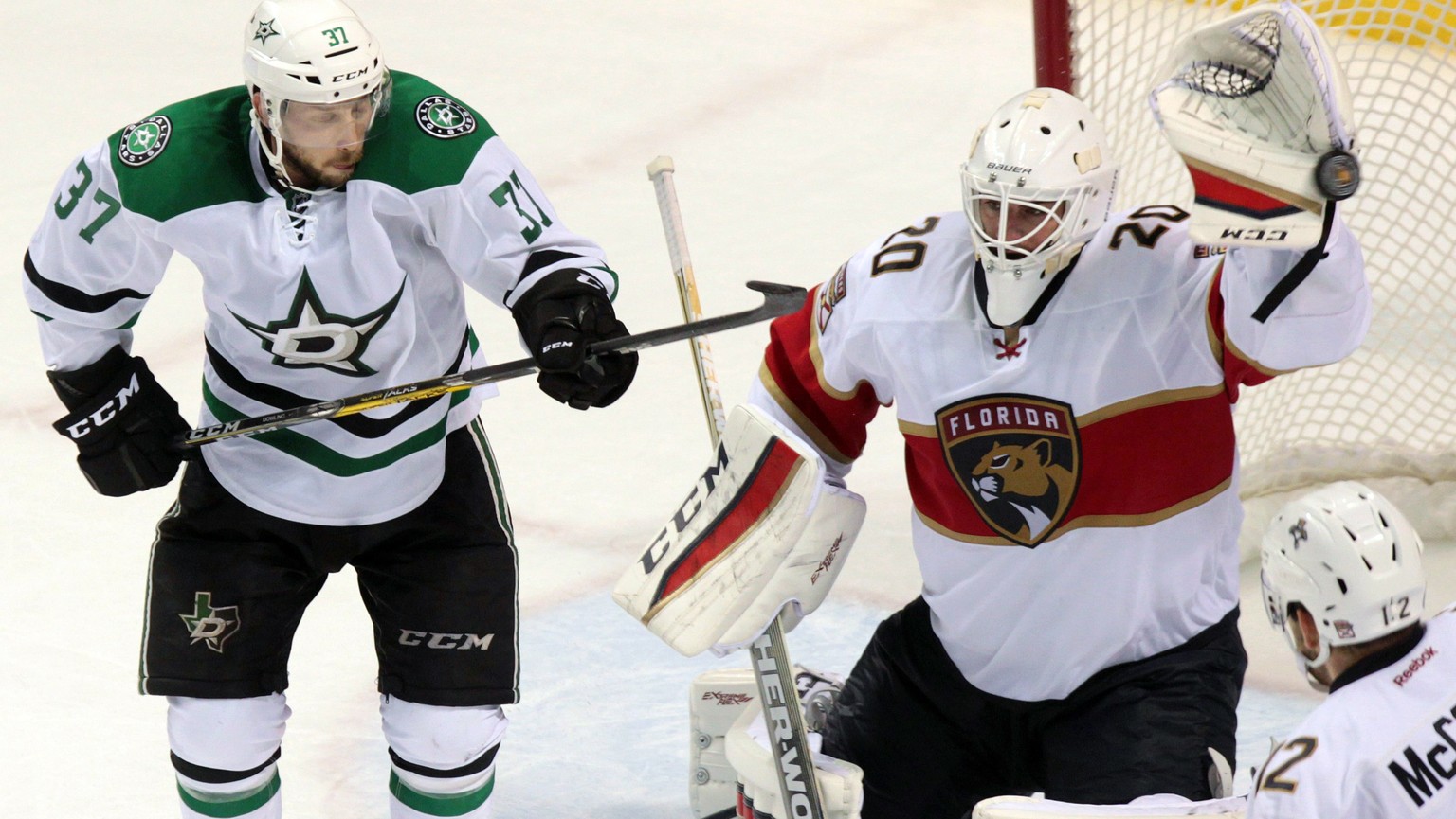 Florida Panthers goalie Reto Berra, right, makes a save on a shot deflected by Dallas Stars&#039; Justin Dowling (37) during overtime NHL hockey pre-season action in London, Ontario, Sunday, Oct. 2, 2 ...