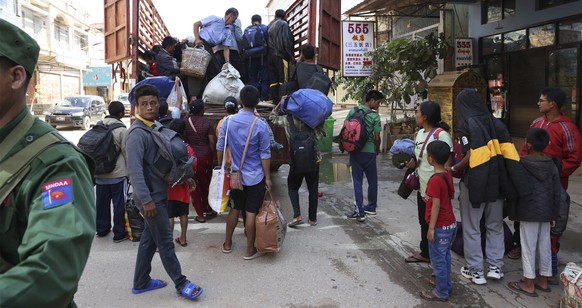 In this photo provided by The Kokang online media, members of the ethnic armed organization of the Myanmar National Democratic Alliance Army herd army battalion soldiers and their family members who...