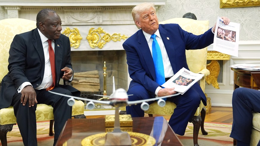 President Donald Trump shows documents as he meets South Africa&#039;s President Cyril Ramaphosa in the Oval Office of the White House, Wednesday, May 21, 2025, in Washington. (AP Photo/Evan Vucci)
Do ...