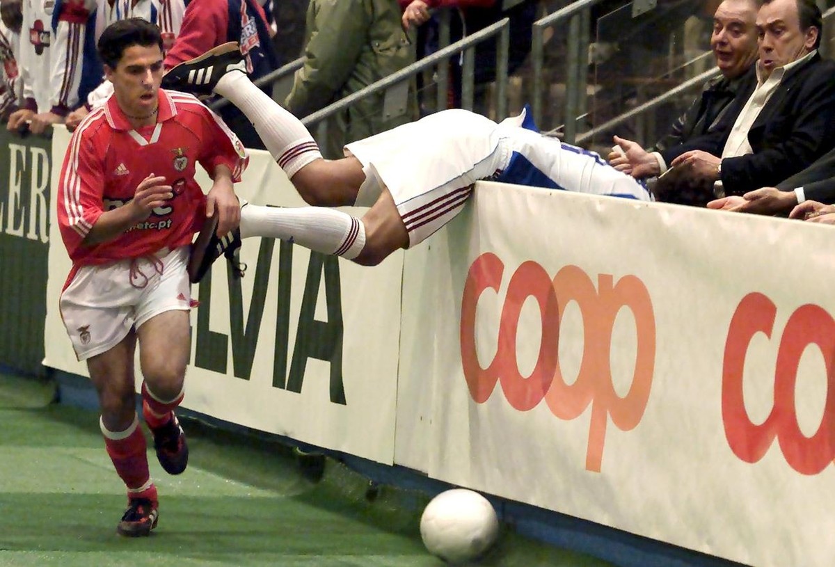 Paolo Diogo of Swiss soccer club Servette, right, falls over the boards while fighting for the ball with Benfica Lisbon's Antonio Livramento, left, during an International indoor soccer tournamen ...