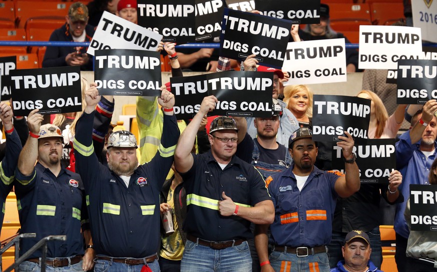 A group of coal miners wave signs for Republican presidential candidate Donald Trump as they wait for a rally in Charleston, W.Va., Thursday, May 5, 2016. (AP Photo/Steve Helber)