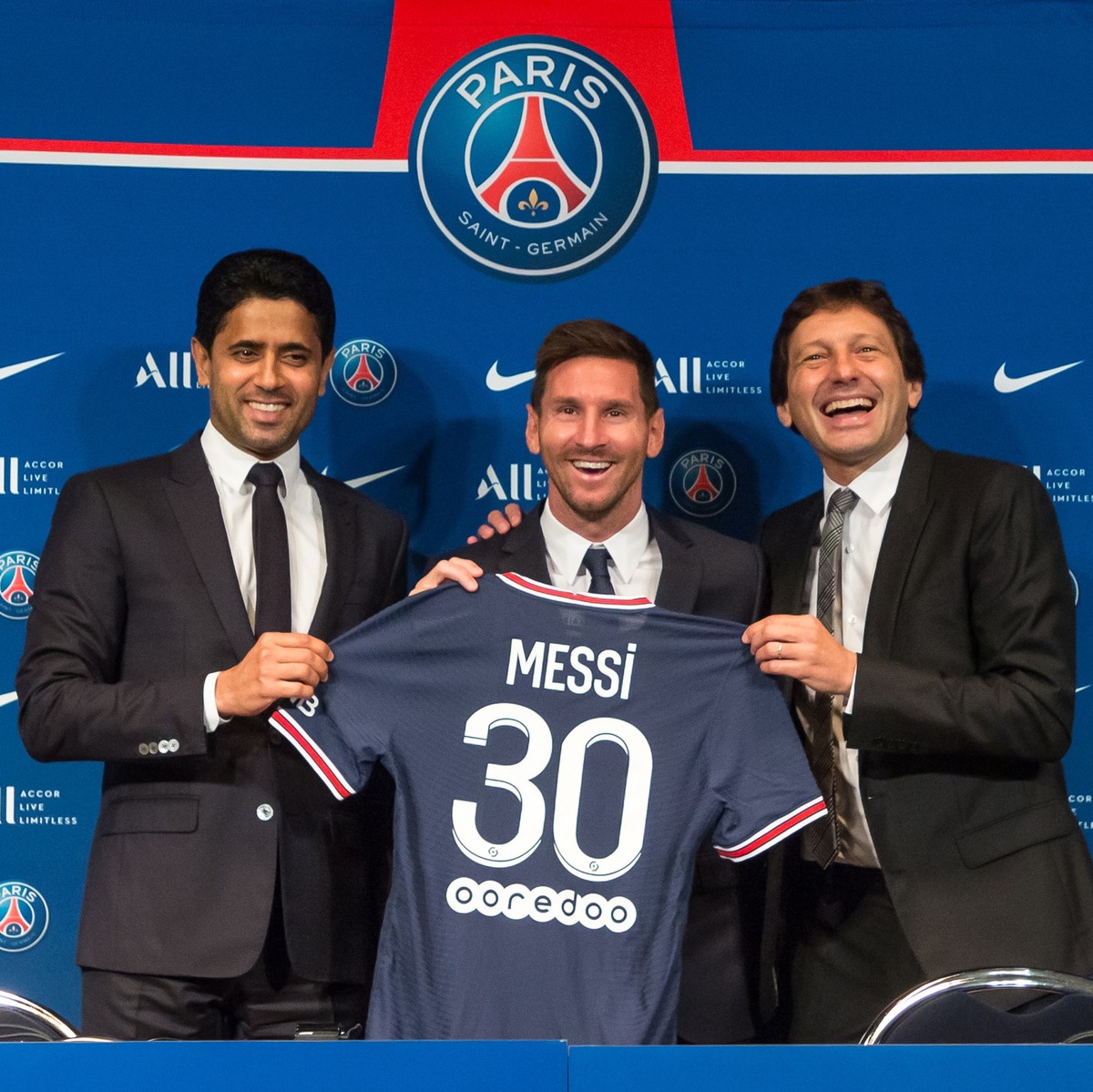 epa09409548 Paris Saint-Germain's president Nasser Al-Khelaifi (L), sports director Leonardo (R) and Argentinian striker Lionel Messi (C) pose with his new PSG jersey after his press conference a ...