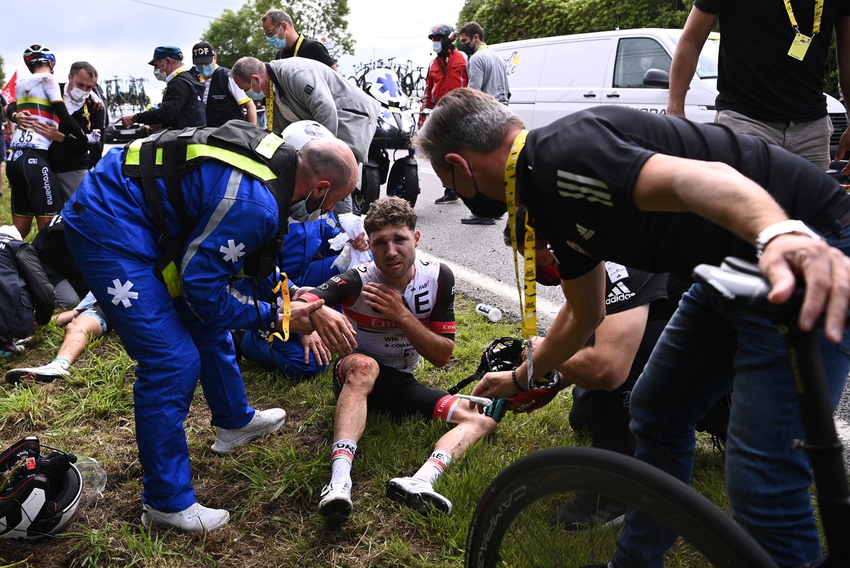 epa09303575 Swiss rider Marc Hirschi of the UAE-Team Emirates (C) receives medical care after a mass crash during the 1st stage of the Tour de France 2021 over 197.8km from Brest to Landerneau, France ...