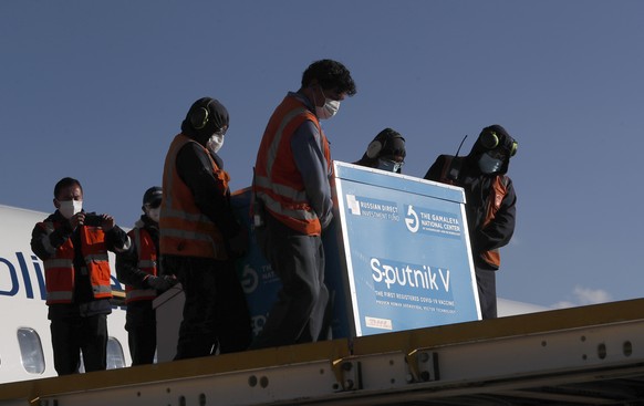 Airport employees unload the first shipment of Russia&#039;s Sputnik V COVID-19 vaccine after it arrived at the international airport in El Alto, Bolivia, Thursday, Jan. 28, 2021. (AP Photo/Juan Karit ...