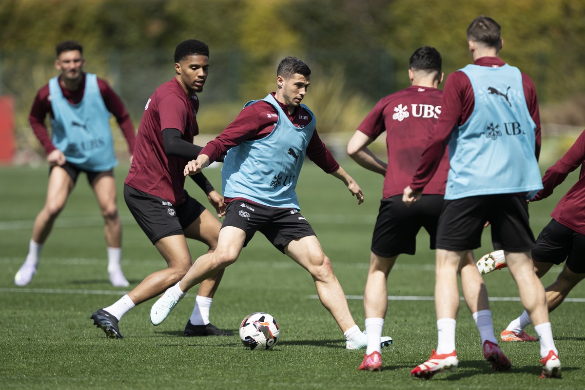 Die Spieler der Schweizer Fussballnationalmannschaft, Simon Sohm, 2. links, und Remo Freuler, Mitte, kaempfem um den ball waehrend einem Training, am Dienstag, 18. Maerz 2025, in The Campus, in Almanc ...
