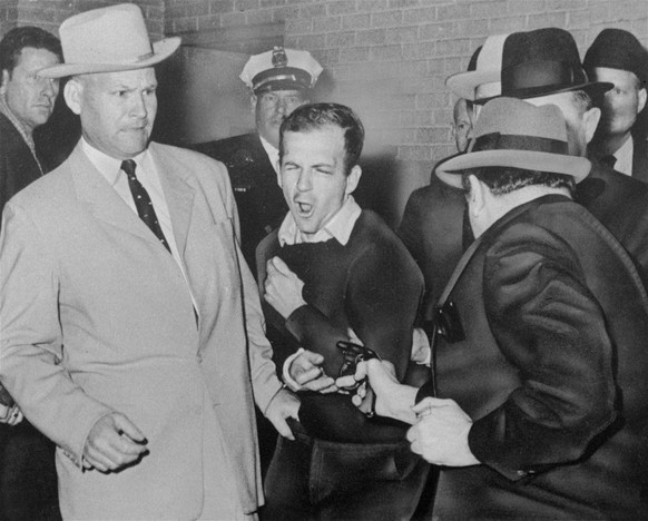 FILE - In this Nov. 24, 1963 file photo, Lee Harvey Oswald, accused assassin of President John F. Kennedy, reacts as Dallas night club owner Jack Ruby, foreground, shoots at him from point blank range ...