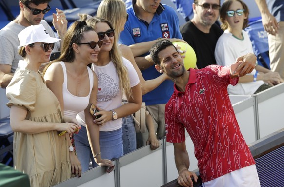 epa08483236 Novak Djokovic of Serbia takes a selfie with his fans after victory against Viktor Troicki of Serbia on the Adria Tour tennis tournament in Belgrade, Serbia, 13 June 2020. The Adria Tour w ...