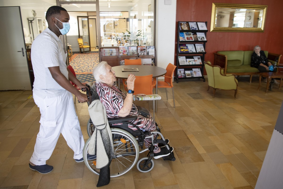 Un soldat des troupes sanitaires de l' Armee Suisse aide une personne agee residente d'un Etablissement Medico-Social, EMS, lors de la pandemie de Coronavirus (Covid-19) ce mardi 12 mai 2020 ...