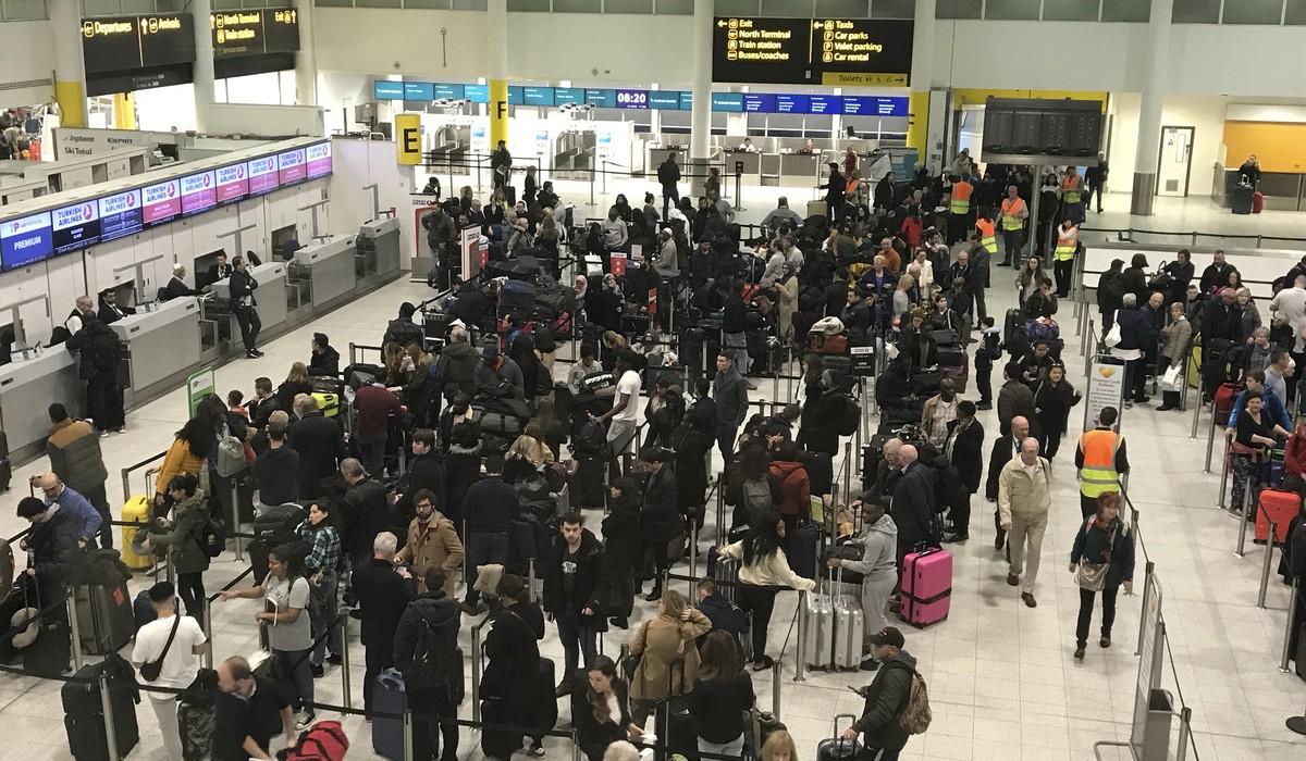 Passengers wait to check in at Gatwick Airport in England, Friday, Dec. 21, 2018. Flights resumed at London's Gatwick Airport on Friday morning after drones sparked the shutdown of the airfield f ...