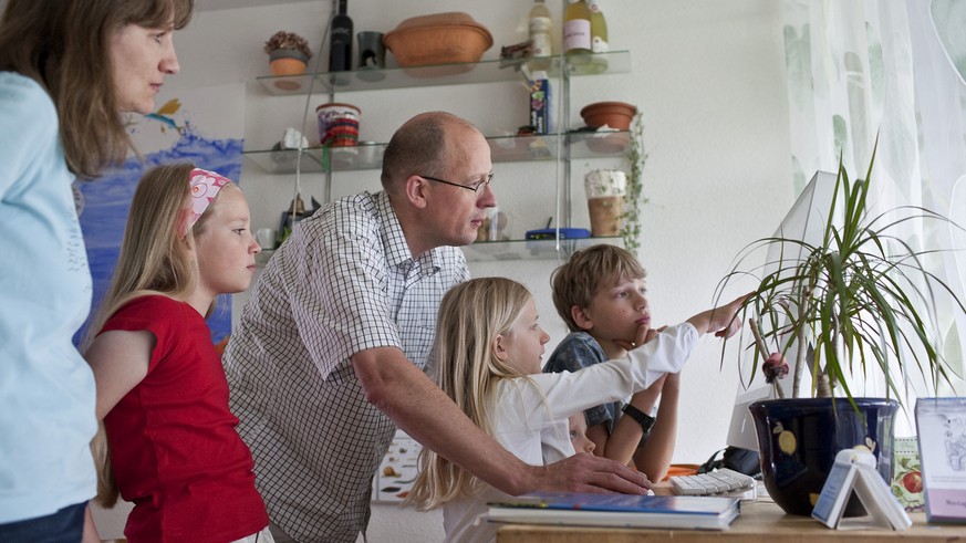 Valentina (left), Sara (midlle) and Oliver (right) work on the computer during a homeschooling lesson with their parents and teachers, pictured on May 12, 2009 in Zurich, Switzerland. (KEYSTONE/Gaetan ...