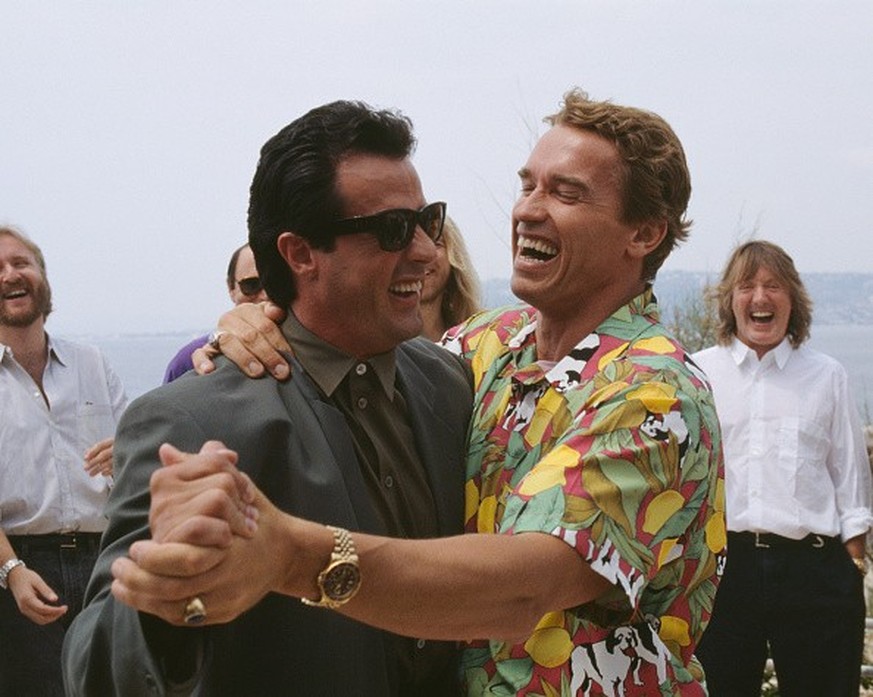 American actor Sylvester Stallone and Austrian born actor, Arnold Schwarzenegger dancing for a joke, during the 43th International Cannes Film Festival 1990 (Photo by Eric Robert/Sygma/Sygma via Getty ...