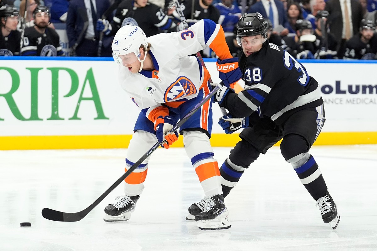 New York Islanders defenseman Adam Boqvist (34) beats Tampa Bay Lightning left wing Brandon Hagel (38) to the puck during the second period of an NHL hockey game Saturday, Dec. 6, 2025, in Tampa, Fla. ...