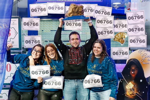 epa11809313 Lottery ticket vendors celebrate selling tickets of the number 06766, that won the second prize of El Nino Lottery, in Barcelona, Spain, 06 January 2025. Every year, Spain holds its tradit ...
