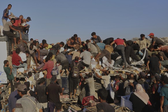 KEYPIX - Palestinians struggle to get food and humanitarian aid from the back of a truck as it moves along the Morag corridor near Rafah, in the southern Gaza Strip, Monday, Aug. 4, 2025. (KEYSTONE/AP ...