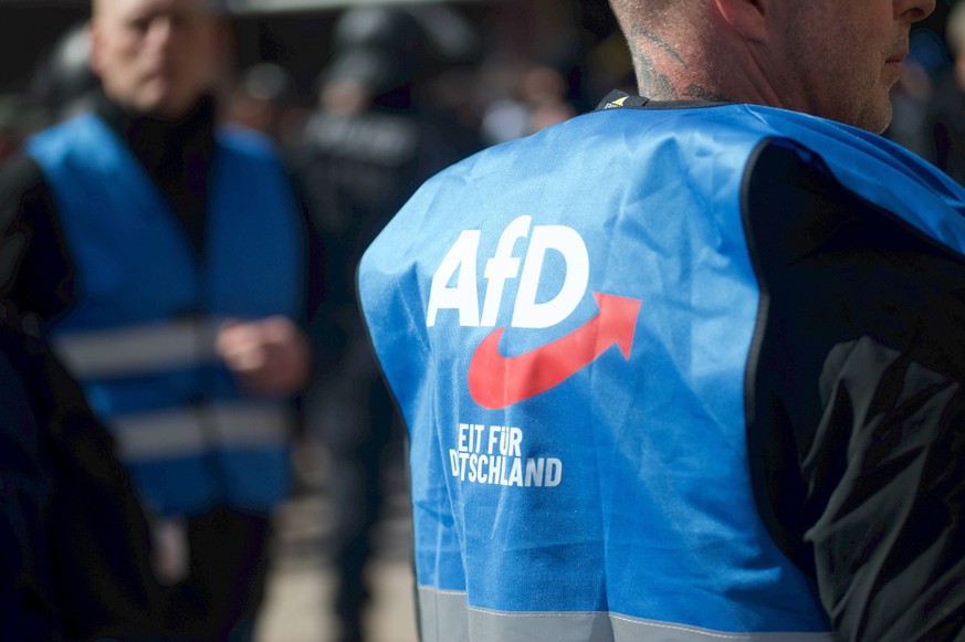 Flensburg, Schleswig-Holstein Demo gegen AfD in Flensburg, Person mit blauer Weste mit Aufschrift AfD. Zeit f�r Deutschland. Nordermarkt. Aufnahme vom 11.04.2026, Flensburg *** Flensburg, Schleswig Ho ...