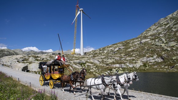 Die Gotthard Postkutsche faehrt am Donnerstag, 20. August 2020 an einem, im Bau befindenden Windrad vorbei. Auf dem Gotthard Pass werden zur Zeit die Windraeder des Windparks der Azienda Elettrica Tic ...