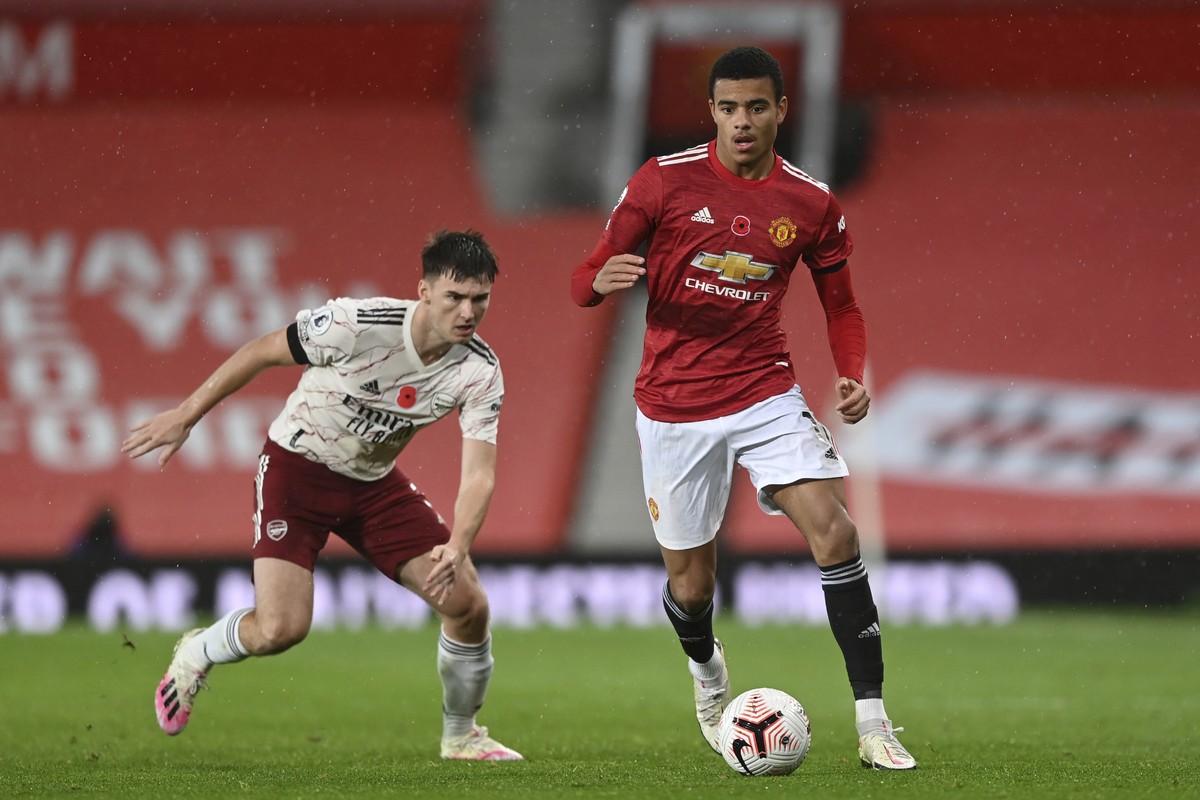 Manchester United's Mason Greenwood, right, runs with the ball past Arsenal's Kieran Tierney during the English Premier League soccer match between Manchester United and Arsenal at the Old T ...