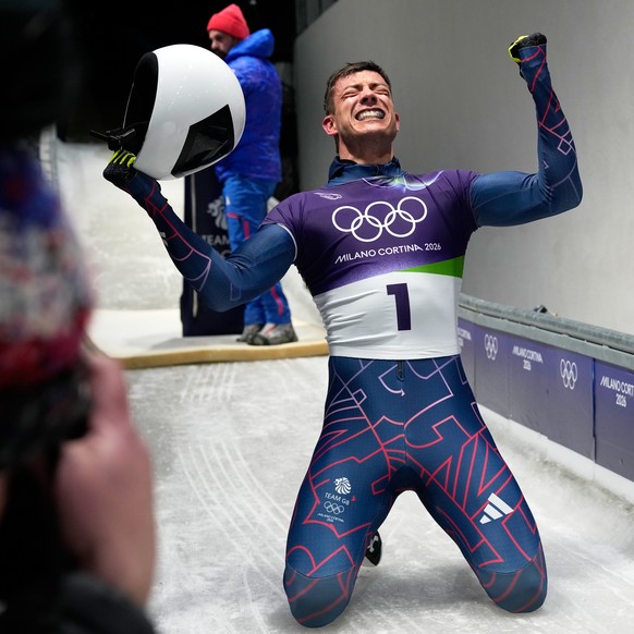 Britain's gold medalist Matt Weston celebrates as he arrives at the finish during a men's skeleton run at the 2026 Winter Olympics, in Cortina d'Ampezzo, Italy, Friday, Feb. 13, 2026. ( ...
