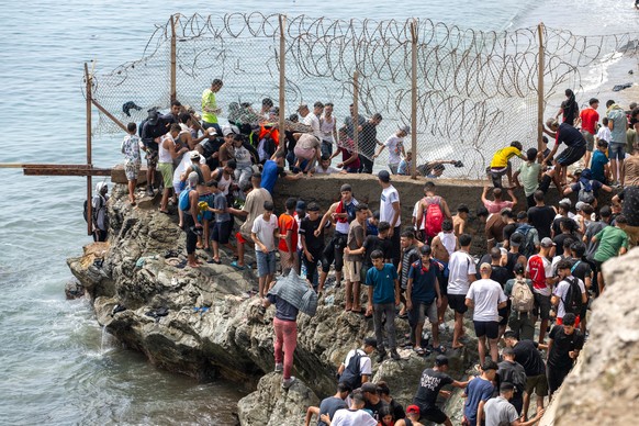 People breach barbed wires as they attempt to cross from the Moroccan northern town of Fnideq to the Spanish enclave of Ceuta, Friday, July 31, 2026. (AP Photo)
Morocco Spain Ceuta