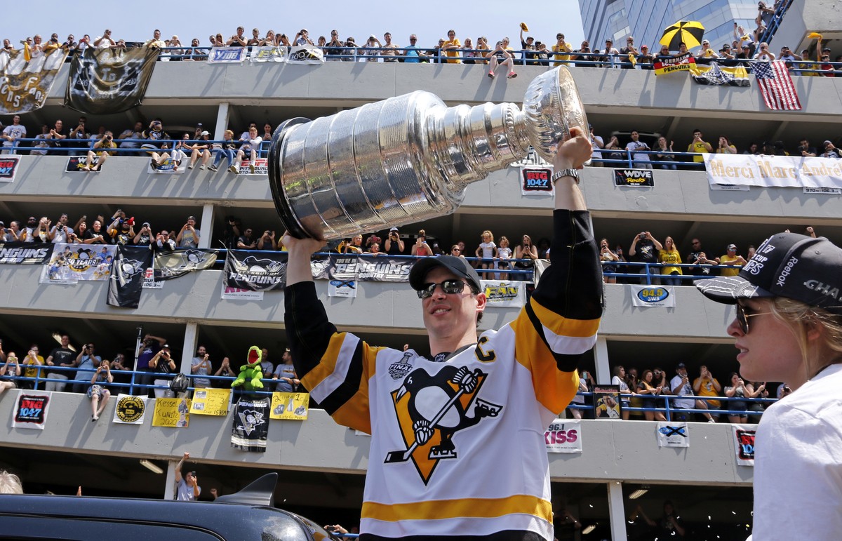 Pittsburgh Penguins' Sidney Crosby hoists the Stanley Cup during the team's Stanley Cup NHL hockey victory parade on Wednesday, June 14, 2017, in Pittsburgh. (AP Photo/Gene J. Puskar)