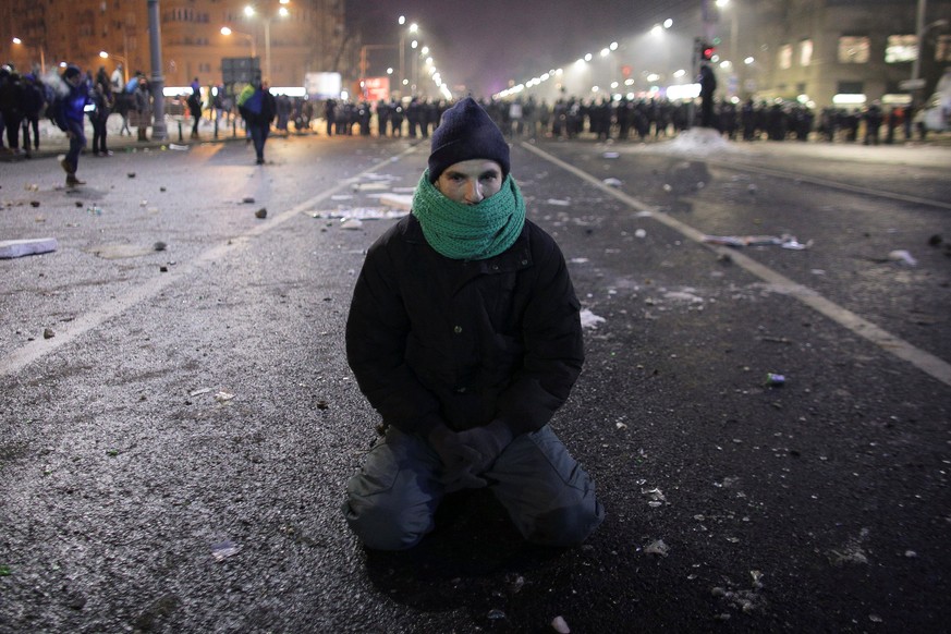 A protestor sits on the ground following scuffles between protestors and Romanian police at a demonstration in Bucharest, Romania, February 1, 2017. Inquam Photos/Octav Ganea via REUTERS ATTENTION EDI ...
