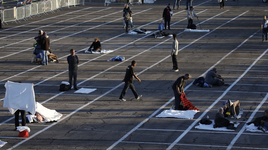 People prepare to sleep in areas marked by painted boxes on the ground of a parking lot at a makeshift camp for the homeless Monday, March 30, 2020, in Las Vegas. Officials opened part of the ot as a ...