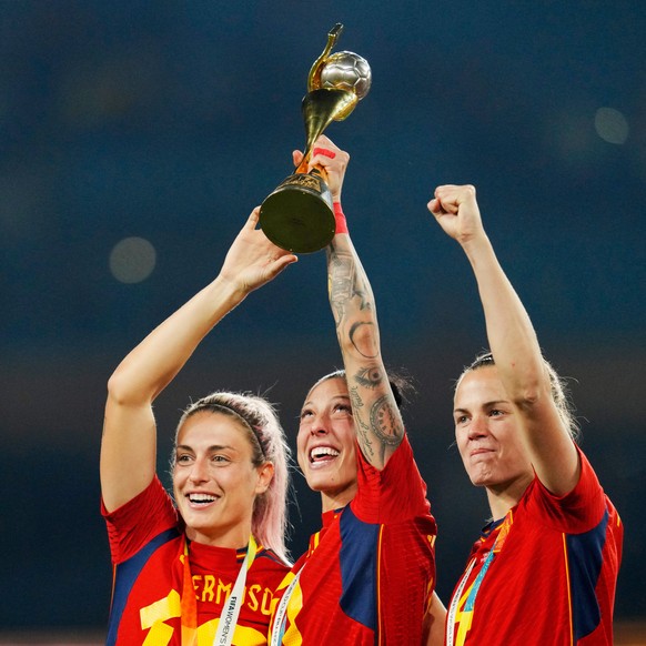 FILE - Spain&#039;s Alexia Putellas, Jennifer Hermoso and Irene Paredes, from left, celebrate with the trophy at the end of the Women&#039;s World Cup soccer final between Spain and England at Stadium ...