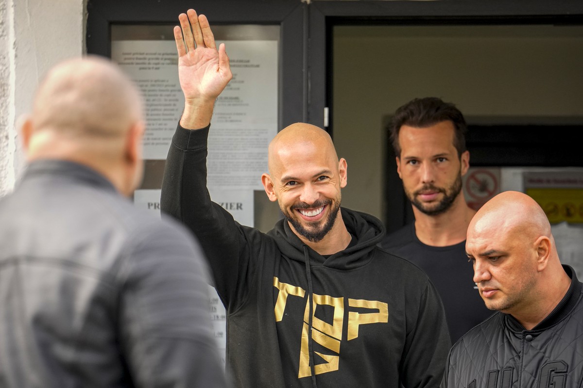 Andrew Tate waves next to his brother Tristan as they check in at a police station as part of their judicial control, which requires them to appear before judicial authorities in Romania when summoned ...