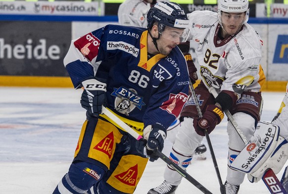 Marco Mueller, links, von Zug im Spiel gegen Torhueter Dominic Nyffeler, rechts, von Genf beim Eishockey Qualifikationsspiel der National League zwischen dem EV Zug und dem HC Geneve Servette am Donne ...