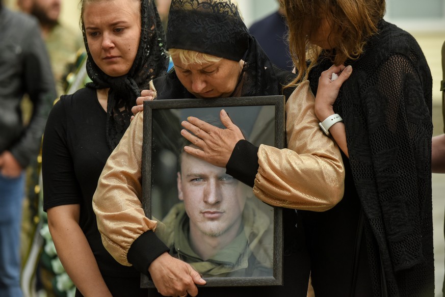 epa10134574 (FILE) - The mother of Ukrainian serviceman Andrii Verkhoglyad holds her son's portrait during his funeral ceremony at St. Michael's Golden-Domed Monastery in Kyiv (Kiev), Ukrain ...
