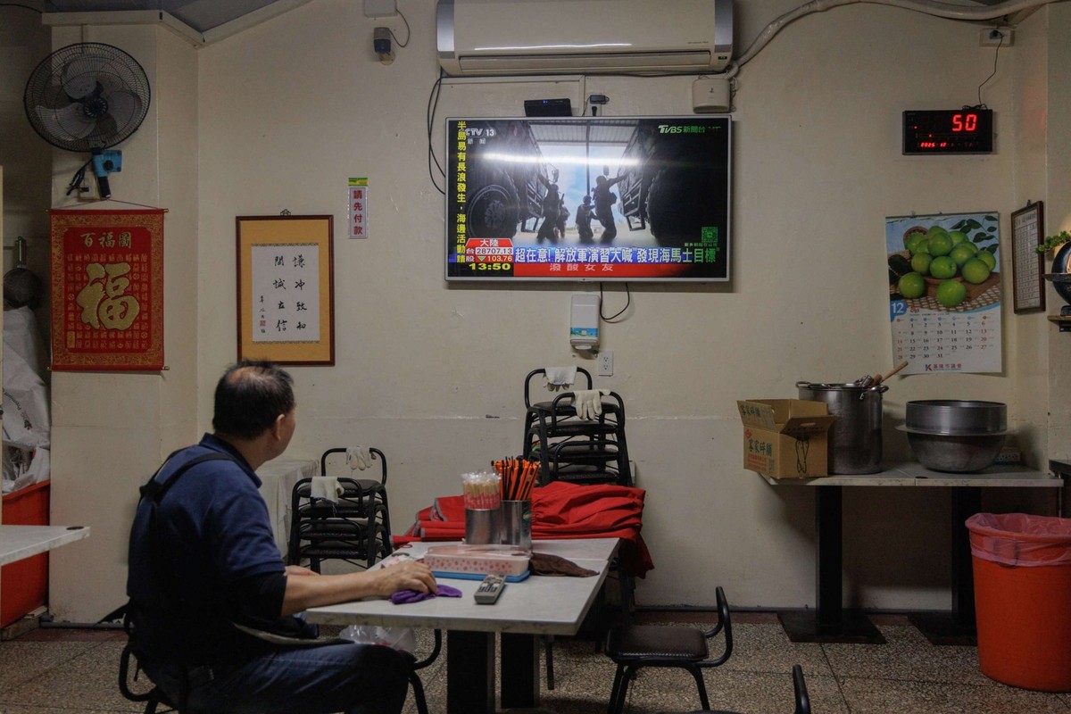 Un homme regarde les informations télévisées consacrées aux exercices militaires de l'Armée populaire de libération chinoise (APL) autour de Taïwan à Keelung, le 30 décembre 2025.