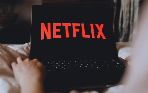 ROSTOV-ON-DON / RUSSIA - March 26 2020: Netflix logo on the laptop screen. young female watching netflix channel sitting at home in the evening