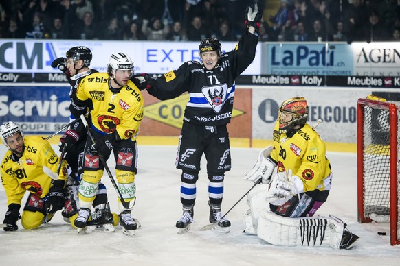 L&#039;attaquant fribourgeois Killian Mottet, centre, leve les bras de joie apres que le gardien bernois Leonardo Genoni, droite, encaisse le but du 1:0 sur un tir du defenseur fribourgeois Andrea Gla ...