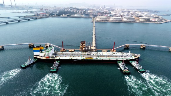 Tugboats push a crude oil tanker into position at a pier handling oil imports in Qingdao in eastern China's Shandong province, Saturday, April 11, 2026. (Chinatopix Via AP) CHINA OUT
China Trade