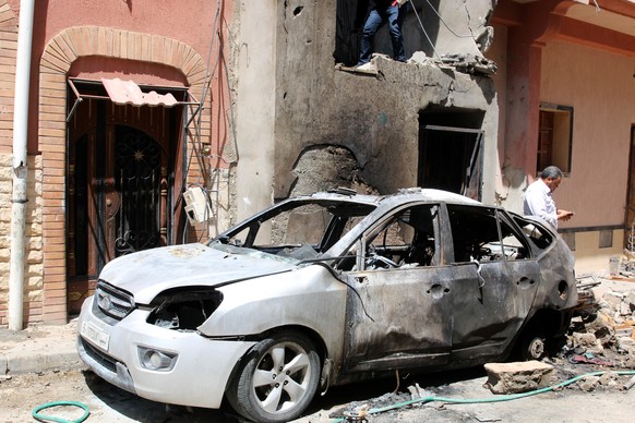 epa07512404 People inspect the damage after overnight shelling on the southern district of Abu Salim, Tripoli, Libya, 17 April 2019. According to media reports, four people were killed and dozens inju ...