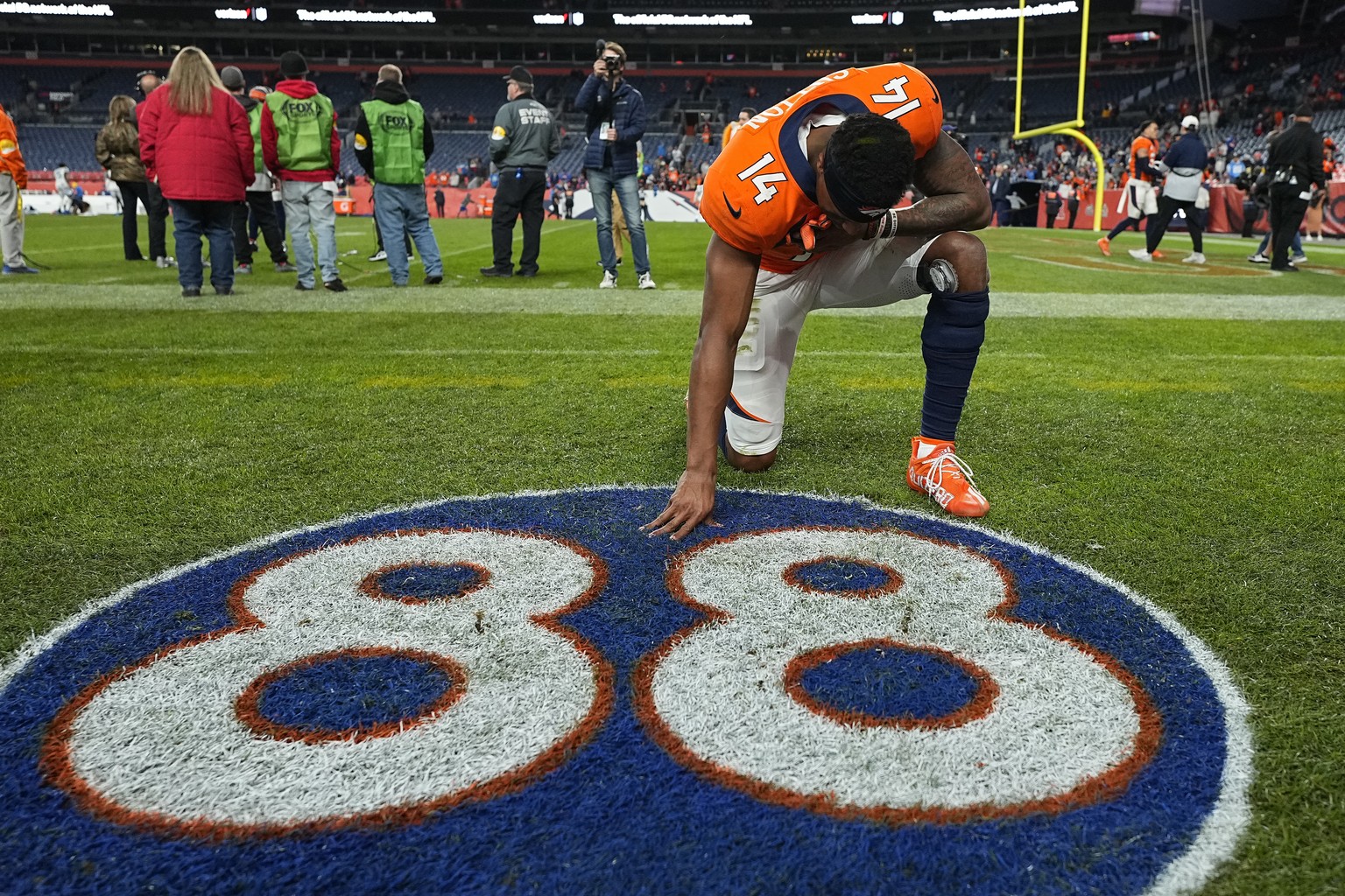 Denver Broncos wide receiver Courtland Sutton (14) kneels at a painted tribute to former Denver Broncos wide receiver Demaryius Thomas after an NFL football game against the Detroit Lions, Sunday, Dec ...